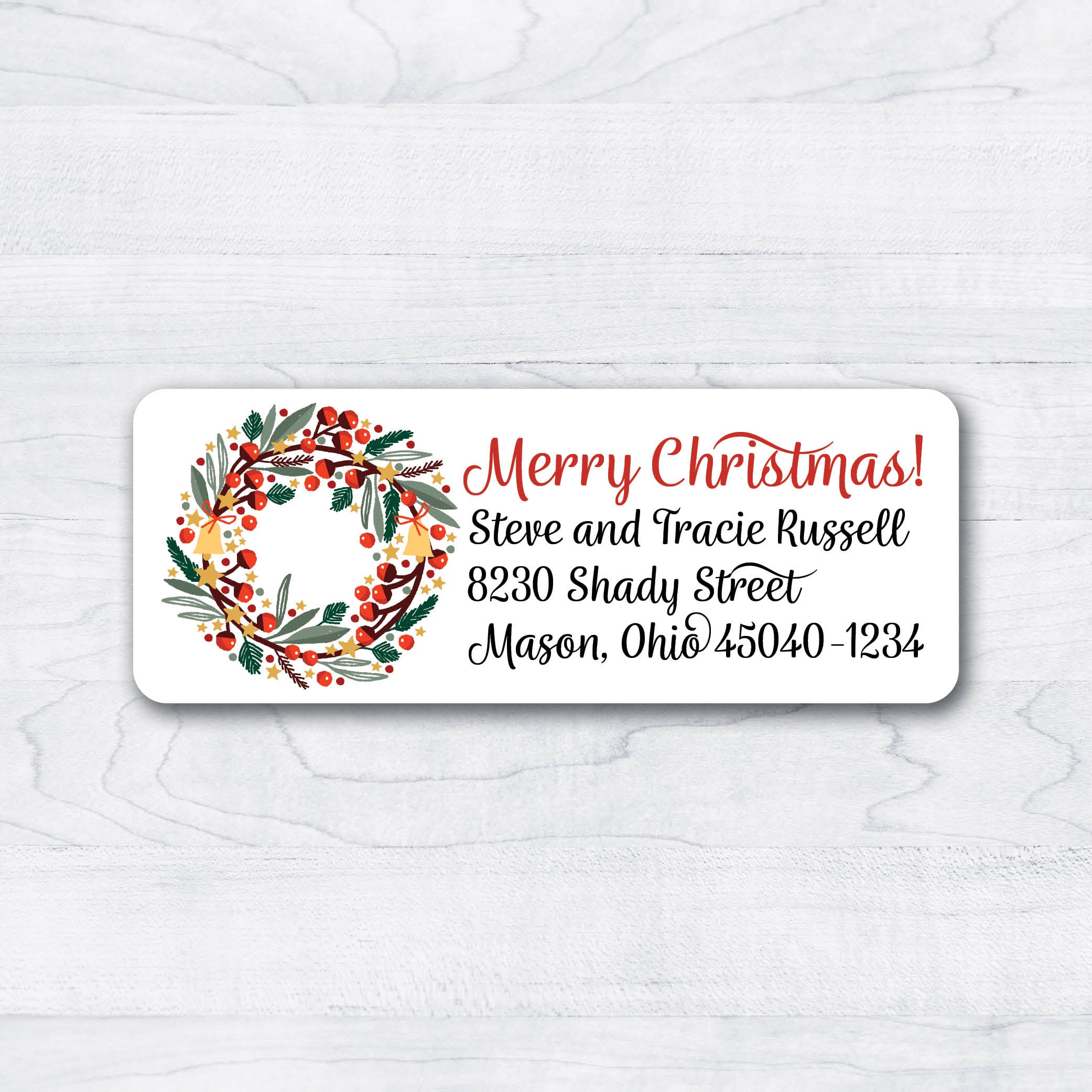 christmas wreath with bells and berries with decorative script return address labels