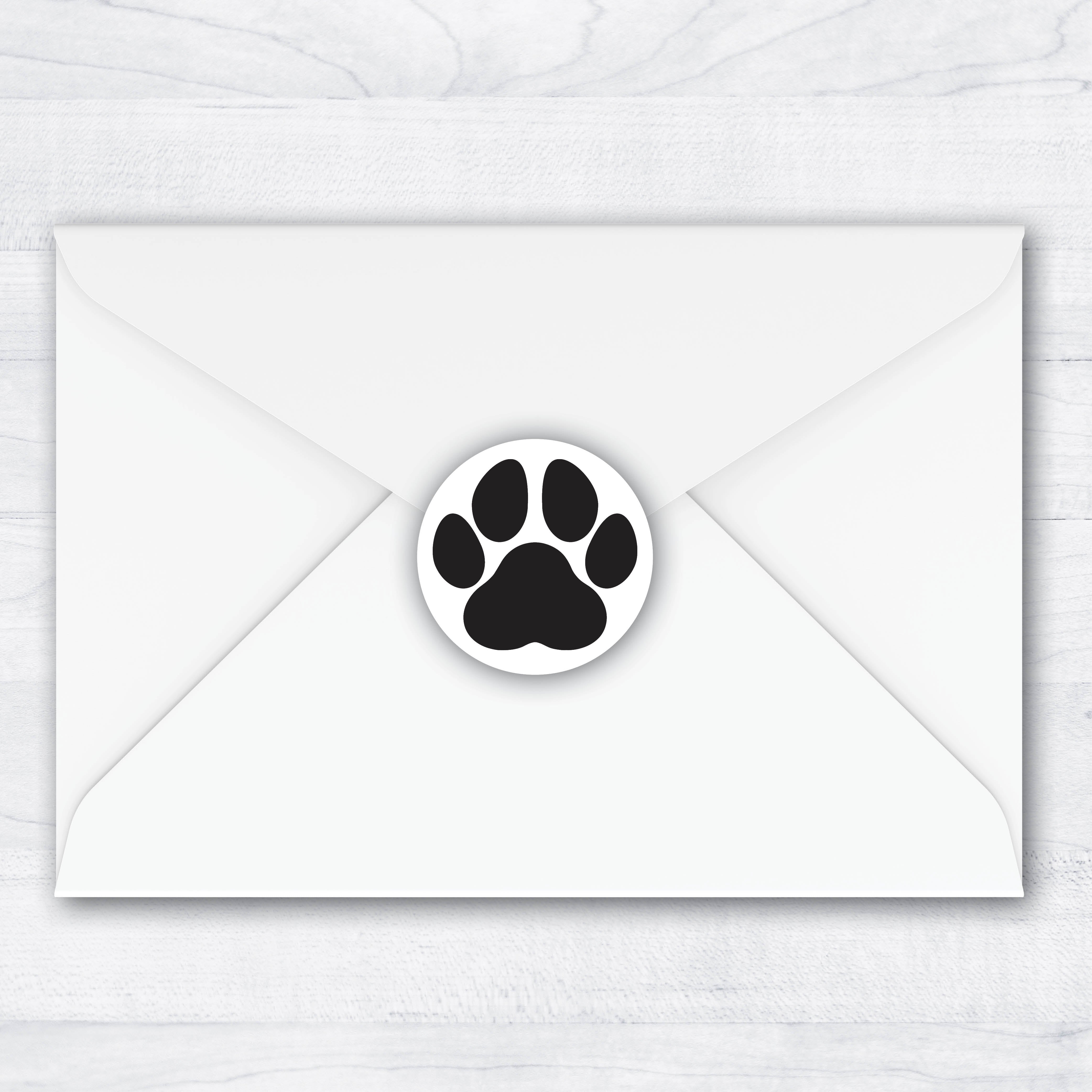 round envelope seal with a black paw print 