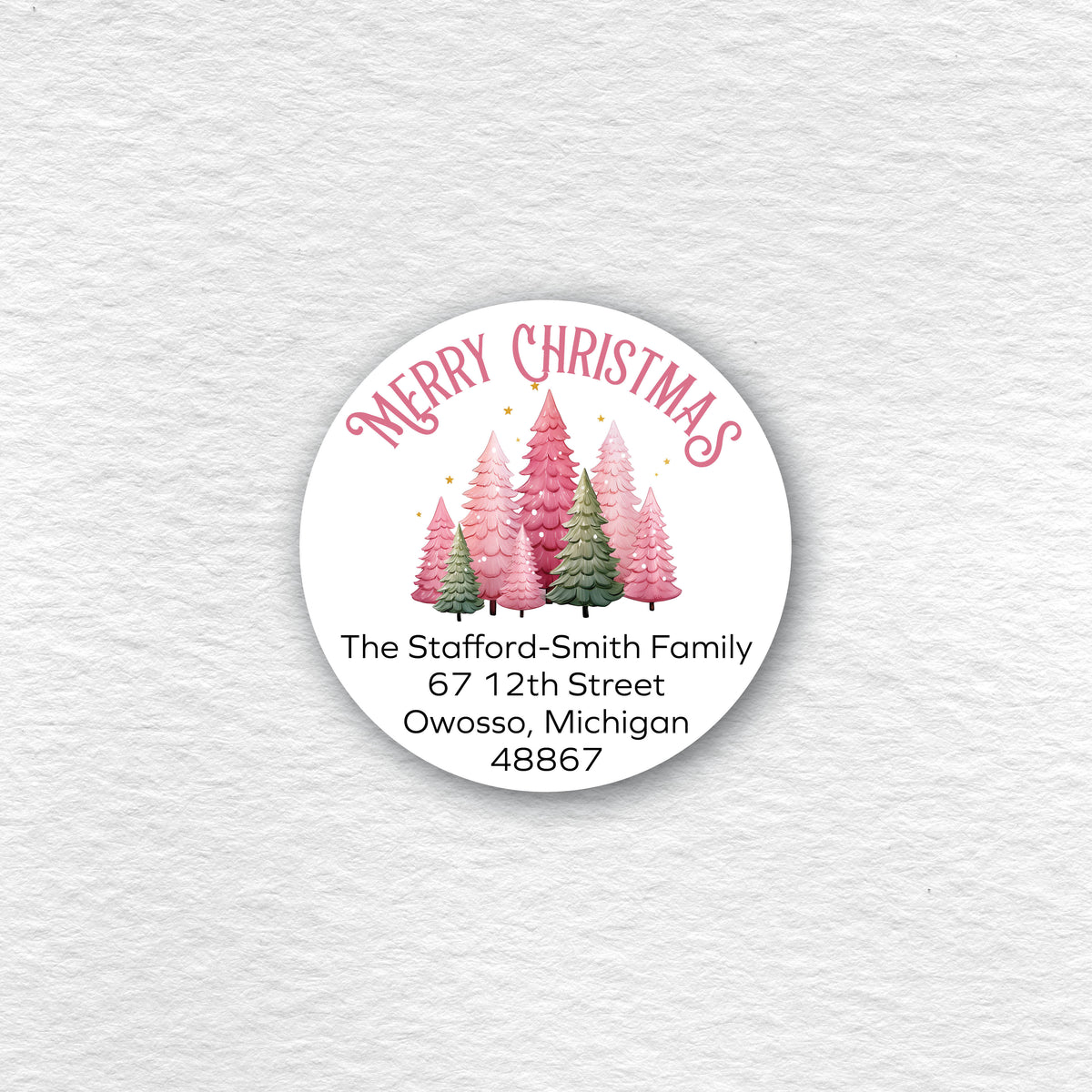 A circular Christmas label on the featuring pink and green Christmas trees.