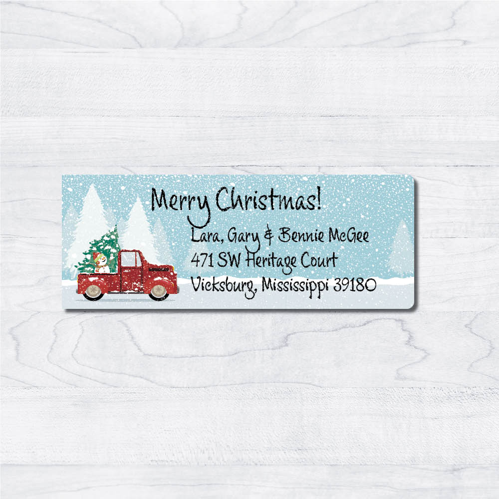 snowman red truck back with earmuffs blue background snowing